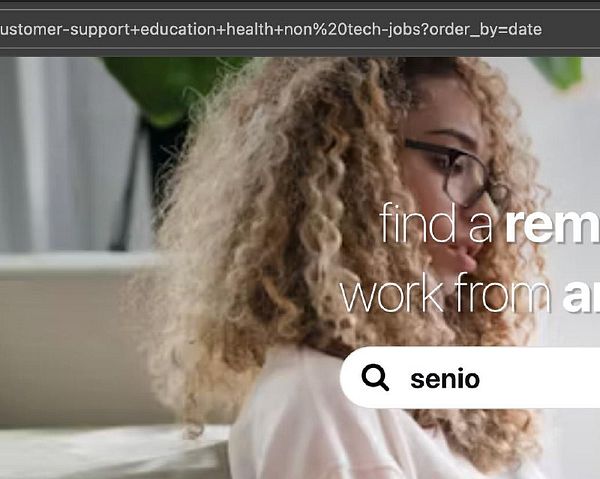 A woman with curly hair is engaged in a task related to remote job searching on a website.