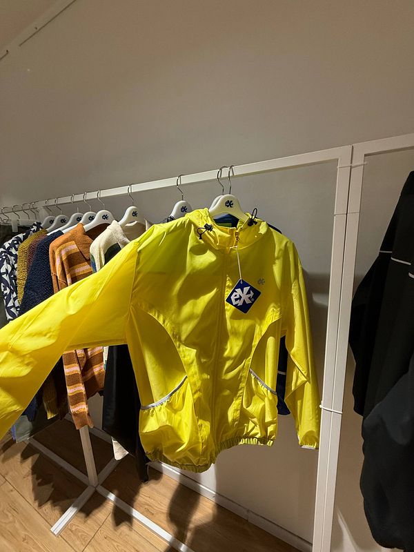 A vibrant street scene at Paris Fashion Week featuring a diverse group of fashionably dressed attendees crossing a street near a pedestrian crossing and luxury storefronts.