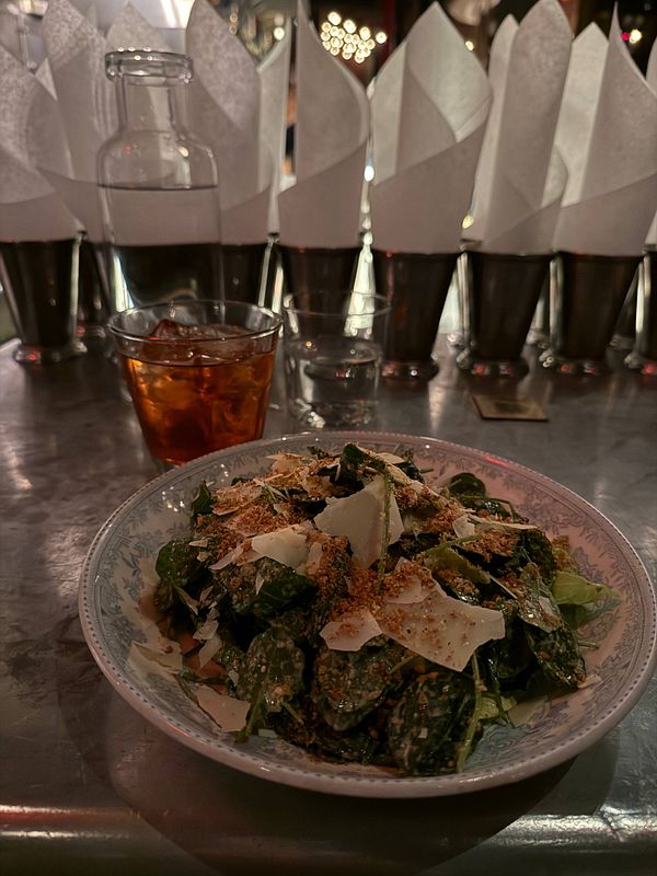 A dish featuring a cooked steak served with sides of grilled vegetables and garlic bread on a white plate.