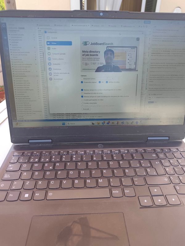 A laptop keyboard with a colorful to-do list notepad and a cup of coffee on a wooden desk.