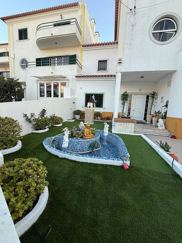 A beautifully landscaped garden featuring a decorative pond and a statue.