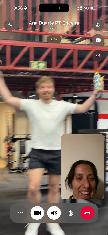 A muscular man with tattoos is performing a push-up exercise in a gym with various fitness equipment in the background.