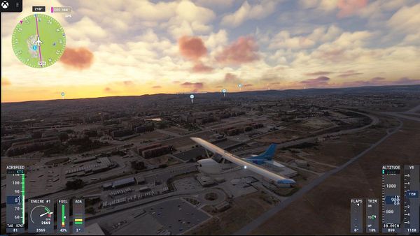 A virtual flight simulation scene in FS2024 showing an aircraft flying over a city during sunset.