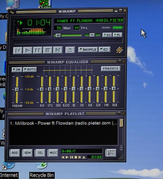 Screenshot of Winamp media player with a visualizer and playback controls on Windows XP.