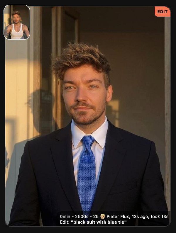 A man in a black suit and blue tie stands confidently in front of a window, with a smaller inset image of him in a tank top.