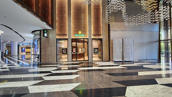 The image captures the entrance of a new Rolex boutique in a luxurious shopping area.