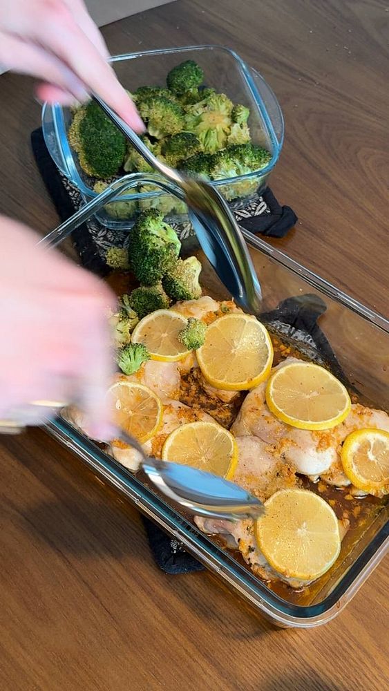Close-up of grilled chicken breast with broccoli garnish on a round plate, lemon wedge on the side.