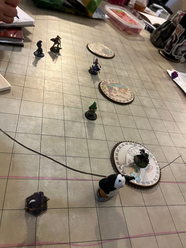 A tabletop scene from a Dungeons & Dragons game featuring various miniatures on a grid map.