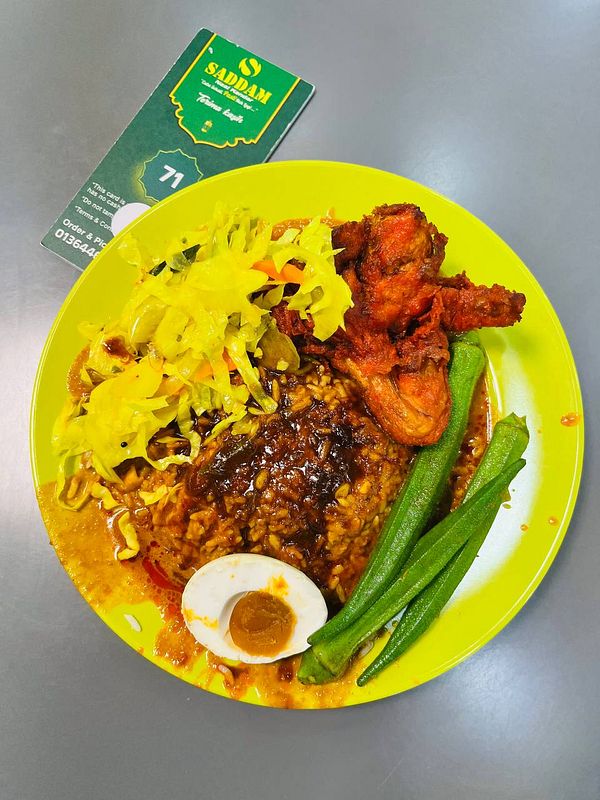 A vibrant plate of nasi kandar featuring various accompaniments.