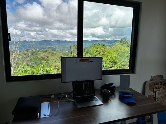 A modern workspace with a stunning mountain view through a large window.