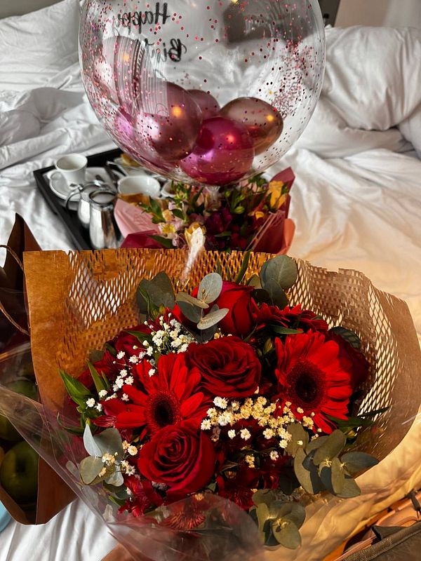 A beautiful birthday surprise featuring flowers and a balloon.