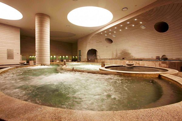 A serene spa environment featuring multiple hot tubs and a modern architectural design.