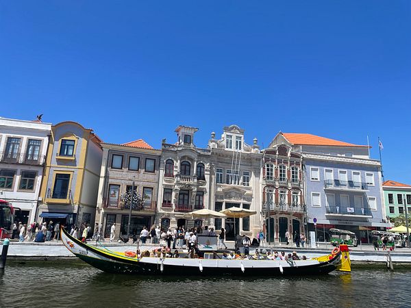 A picturesque view of a canal in Aveiro featuring traditional boats and colorful buildings.