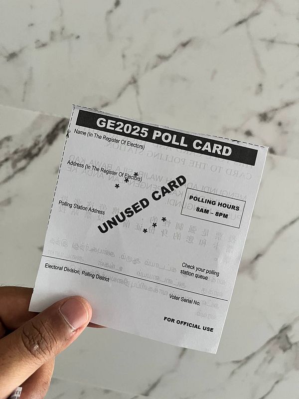 A hand holds a GE2025 poll card against a marble background.