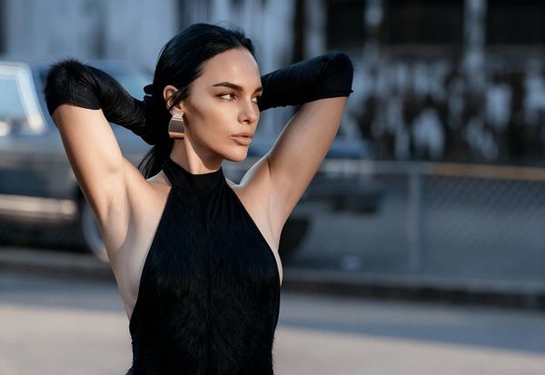 A model poses confidently outdoors, showcasing a striking fashion look.