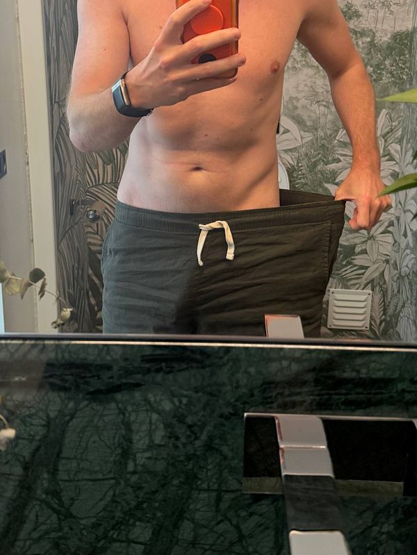 A photograph of a person wearing no pants, showcasing a lean waist and abdomen with the hashtag #biomarkers written in pale ink on the left shoulder.