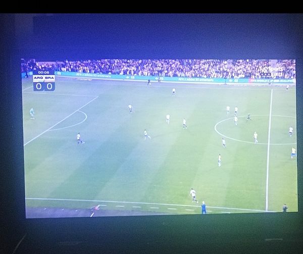 A live broadcast of a soccer match between Argentina and Brazil is displayed on a television screen.