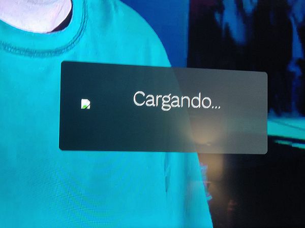 The image displays a loading screen on a television with the text 'Cargando...' indicating that content is being loaded.