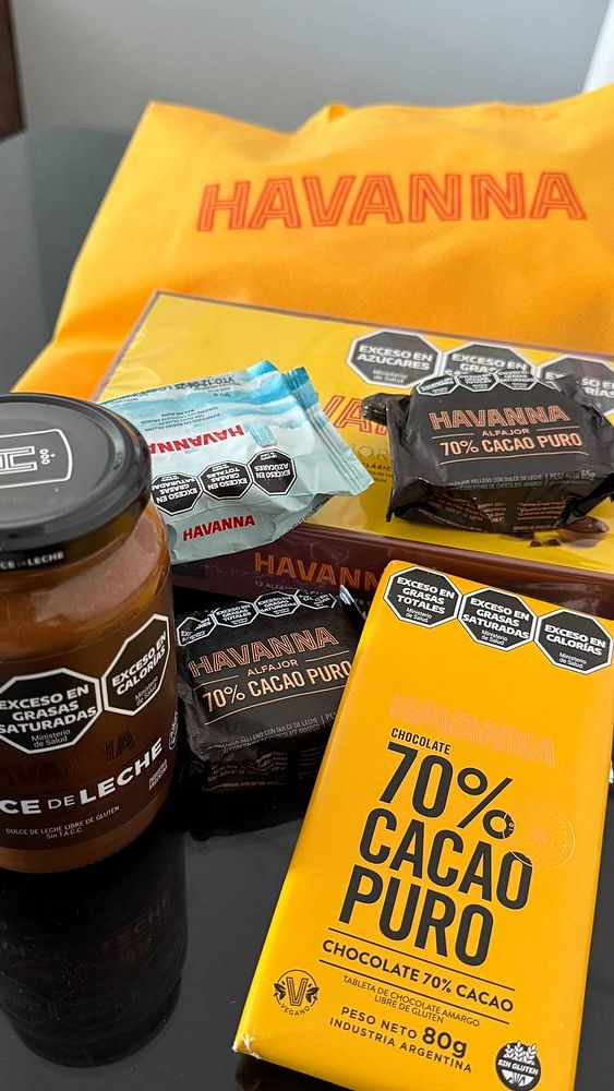 A collection of Havanna products including alfajores and dulce de leche, arranged on a black surface.