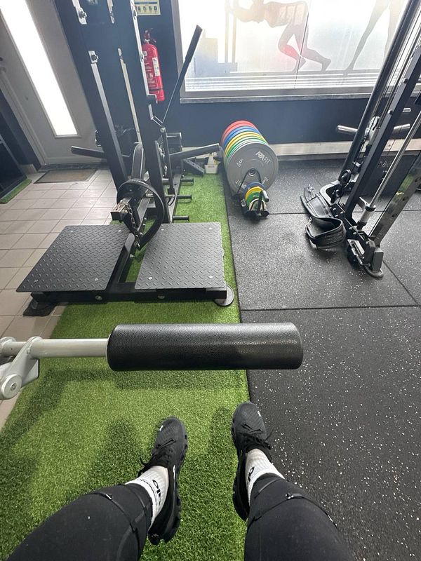 The image captures a gym environment with workout equipment and a view of the floor.