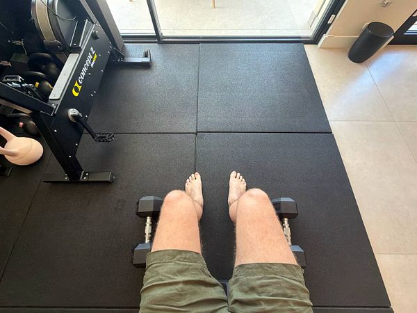 Photo of a modern gym with cardio equipment, dumbbells, and exercise balls in a bright, spacious room.