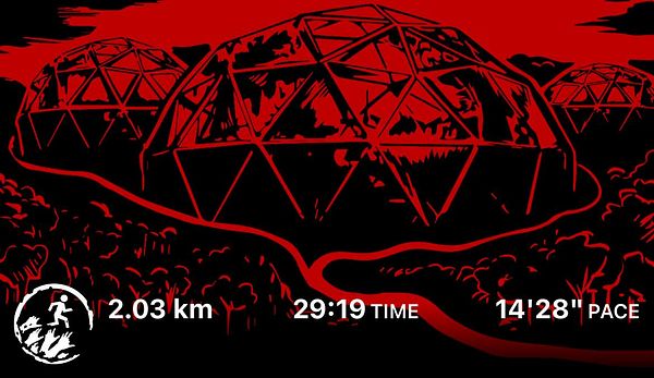 A group of six people sitting outdoors around a carved wooden table and bench in a sunny, tropical garden setting.