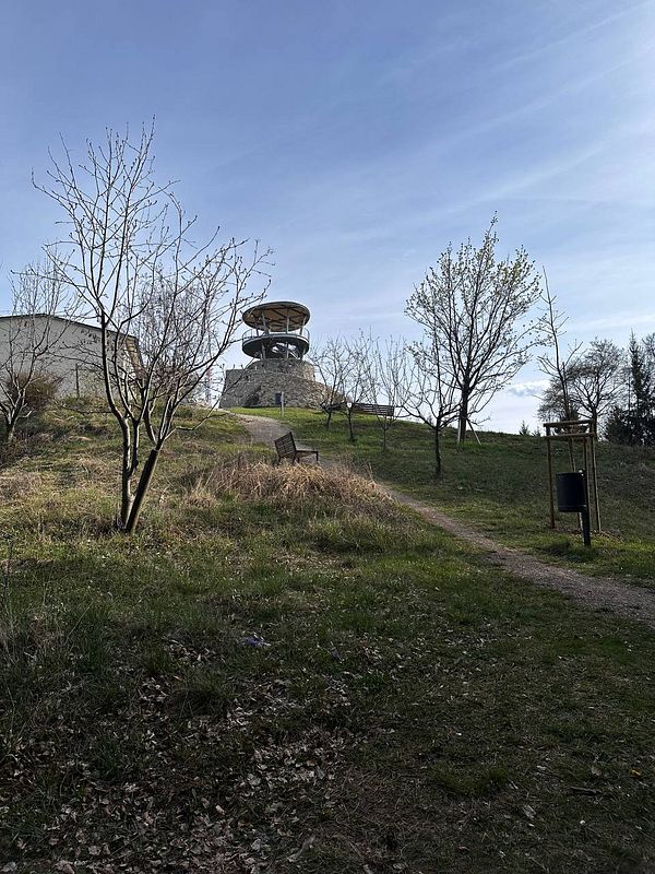 A scenic view of a hill with a lookout tower and a path leading up to it.