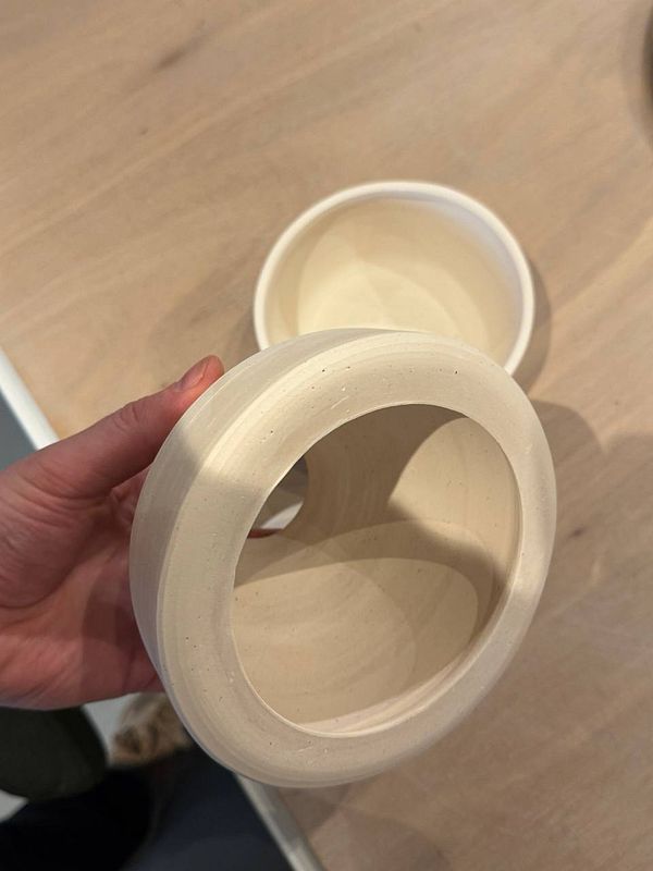 A pair of hands shaping pottery on a spinning potter's wheel.