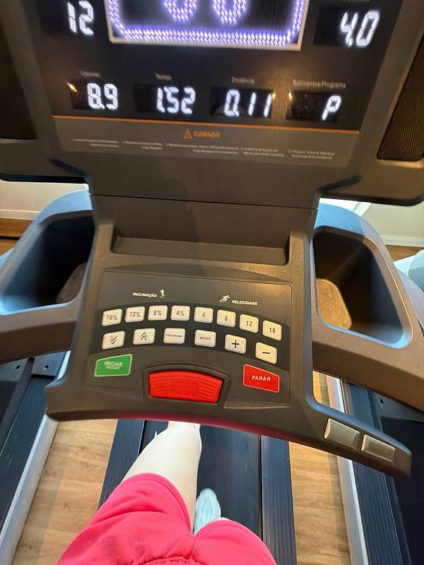 Photo of a muscular man with tattoos working out on fitness equipment in a gym.