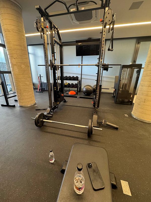 A well-equipped gym space featuring various workout equipment and personal items.