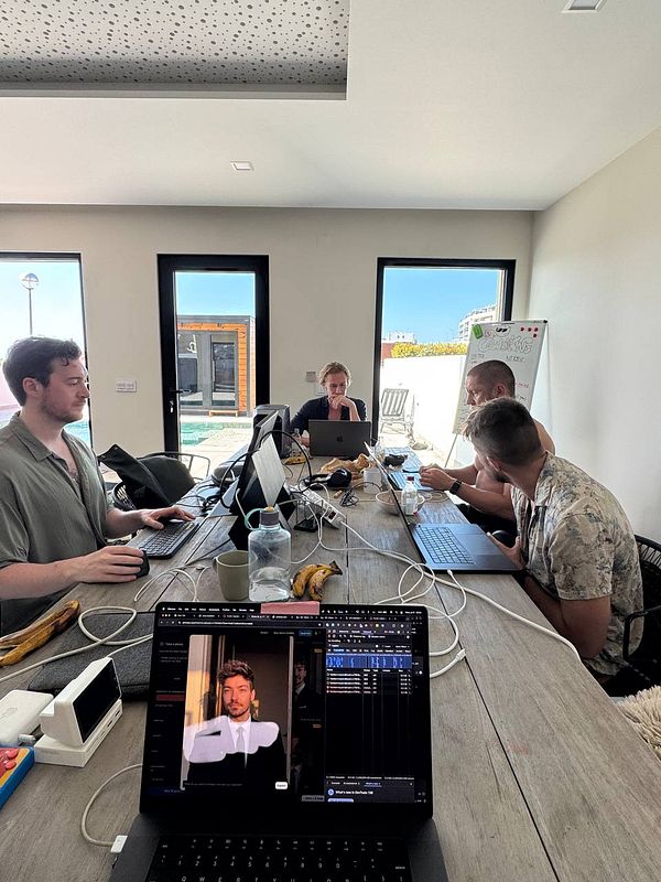 A group of people is engaged in a coworking session at a modern workspace.
