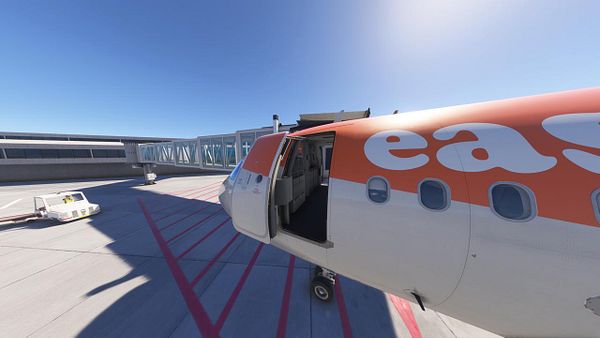 An aircraft is parked at an airport gate with its door open, ready for boarding.