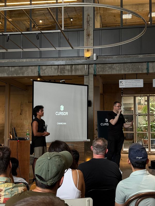 A presentation at the Cursor meetup in Chiang Mai featuring two speakers and an engaged audience.