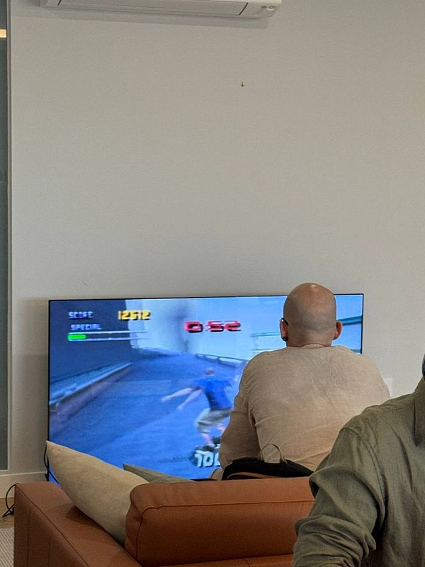 A person is playing a video game on a large screen in a casual setting.