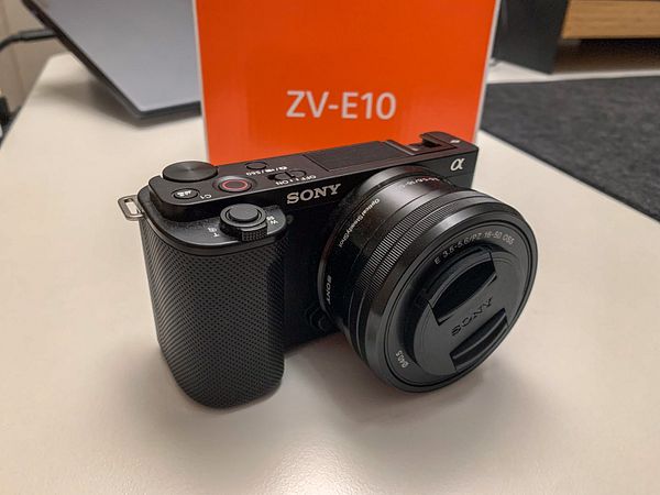 A Sony ZV-E10 camera is prominently displayed on a table.