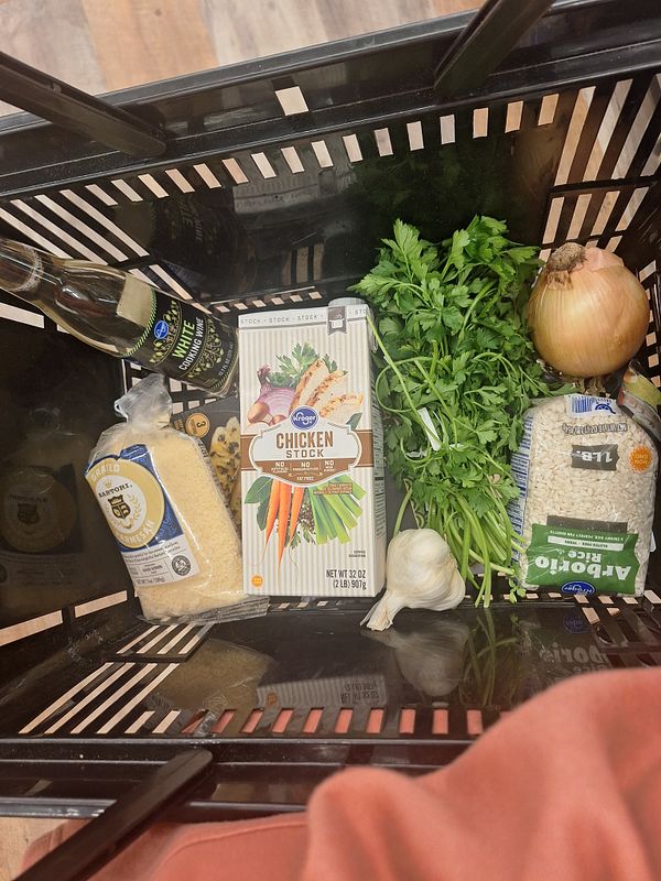 A grocery basket filled with ingredients for making tilapia and parmesan risotto.