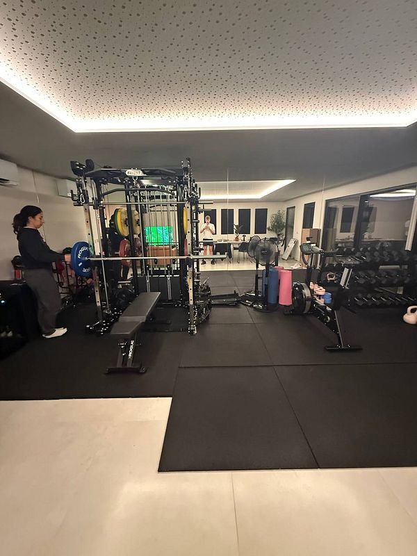 A well-equipped home gym featuring various workout stations and equipment.