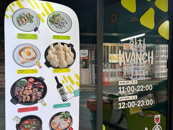 Street scene in a Soviet-style neighborhood in Seoul with residential buildings, parked cars, and a pedestrian.