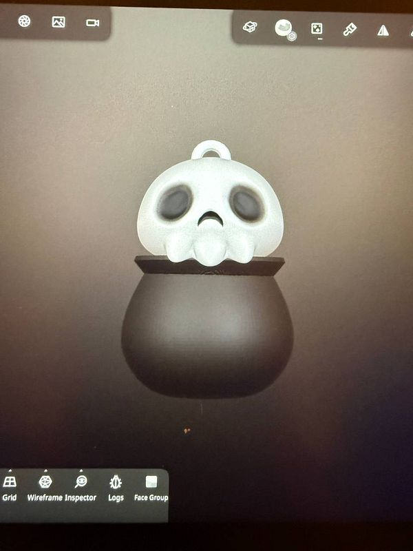 A 3D model of a skull-shaped keychain design is displayed on a digital interface.