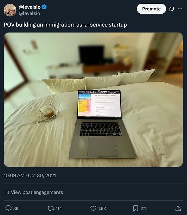 A cozy workspace setup on a bed featuring a laptop and a cup of coffee.