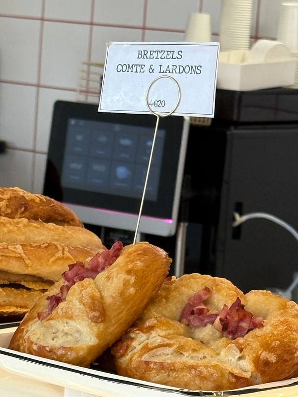 A display of bacon pretzels with a price tag in a food setting.