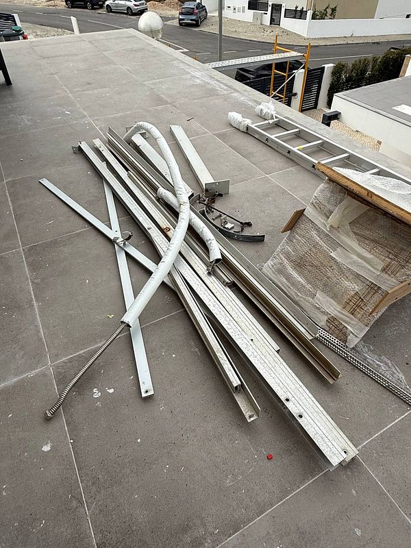 A disorganized pile of metal and equipment left on a rooftop after solar panel installation.