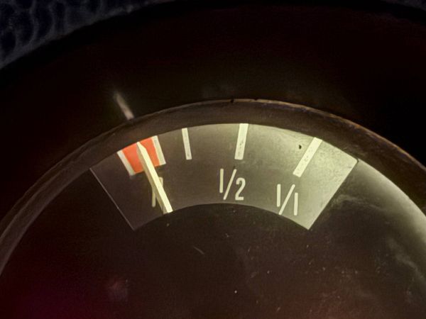 A man sleeping on a street bench at night in an urban setting decorated with colorful lights and parked scooters.