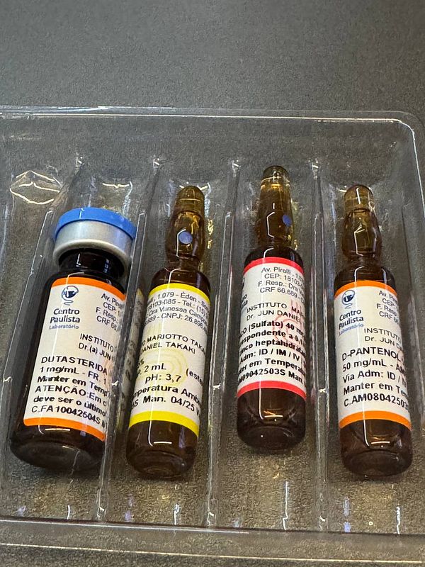 The image displays a set of four medical vials arranged in a plastic tray.