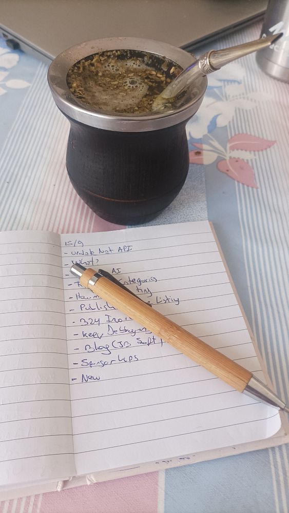 A cozy workspace featuring a traditional mate cup, a notebook with a to-do list, and a pen.