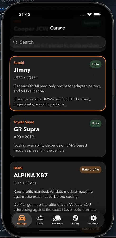 Front view of a dark grey Suzuki Jimny parked on a street with a residential background.