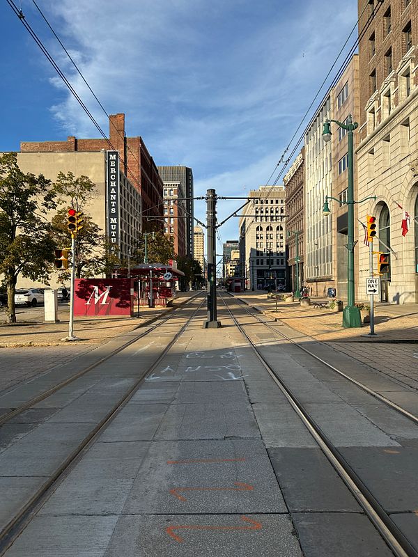 A view of a city street in Buffalo featuring tram tracks and surrounding buildings.
