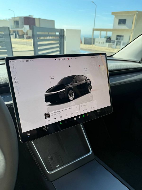 The image features the interior of a Tesla Model Y with a display showing a digital interface.